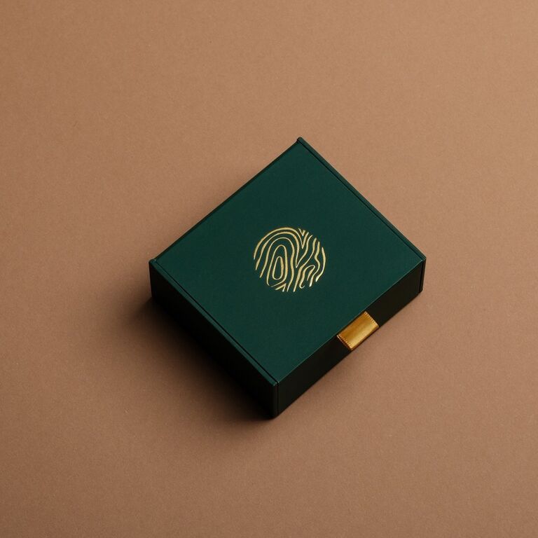 "Gift Box Rings": Elegant green gift box with gold detailing and sleek design.