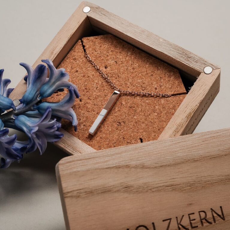"Campania Halskette" Halskette mit Marmor- und Ros&eacute;gold-Akzenten in einer Holzvitrine.